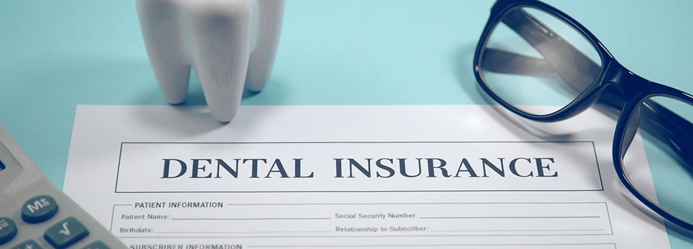 Dental insurance form, eyeglasses, and calculator on blue background